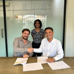 Phloeun (AAOO) and Alexandre (melon rouge) shaking hands and smiling with Lakshmi looking on