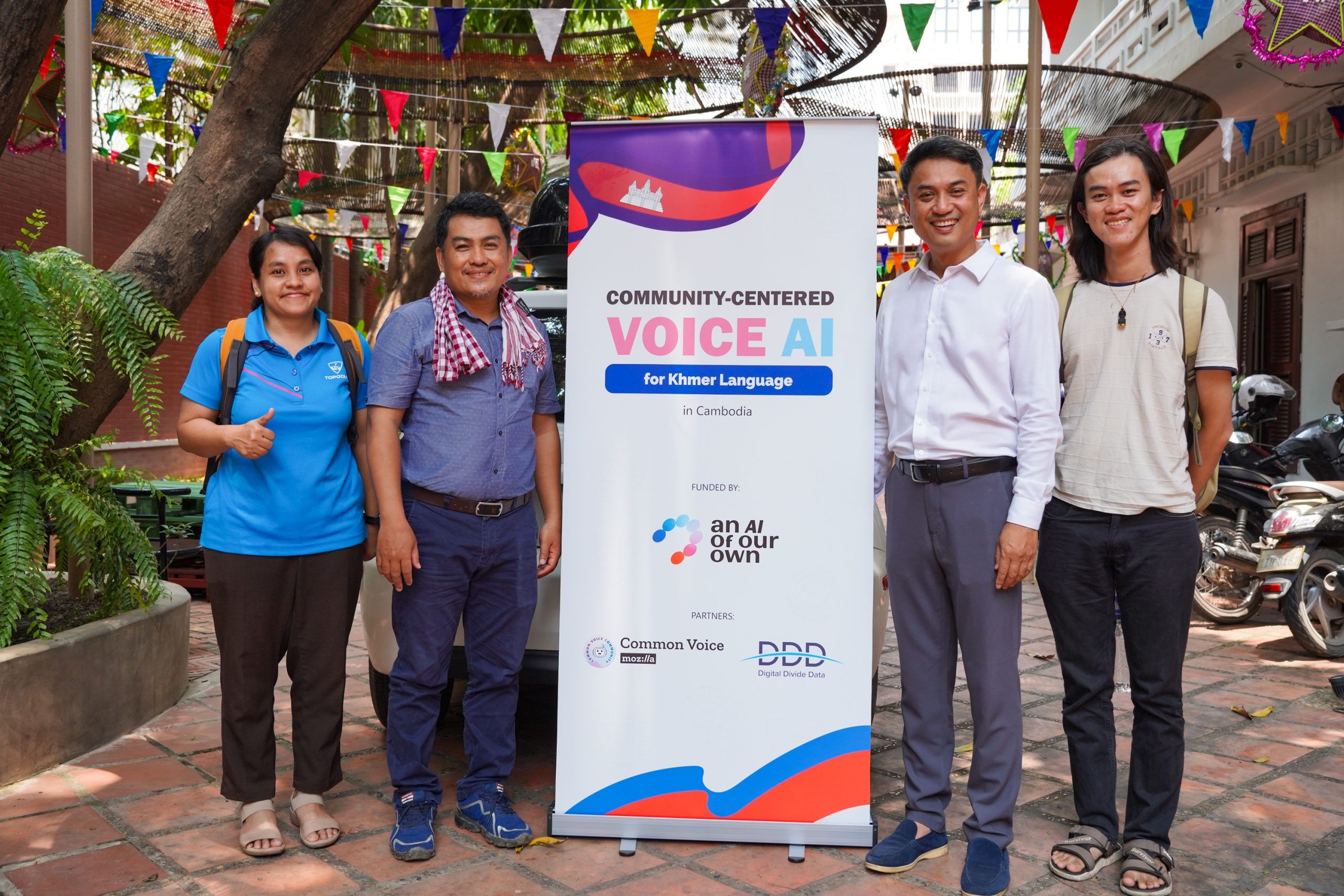 AAOO staff and workshop facilitators stand next to the workshop banner