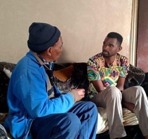 Tatenda is sitting listening to a community member speak